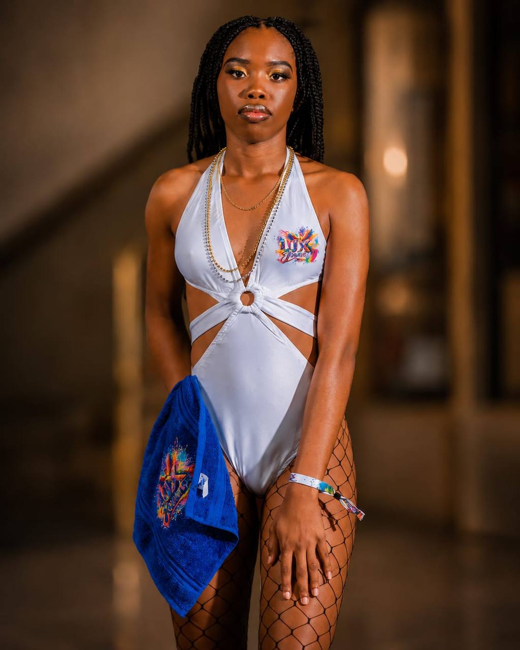Masquerader in a white LUX J'Ouvert monokini with festival towel