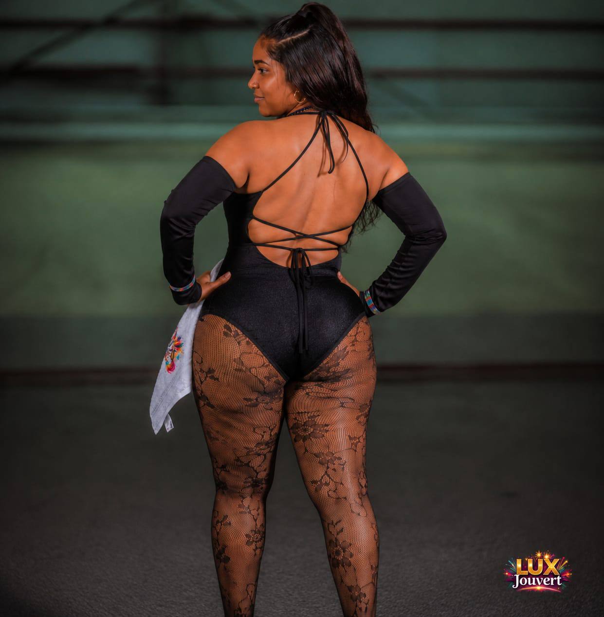 Back view of masquerader in black costume with lace tights