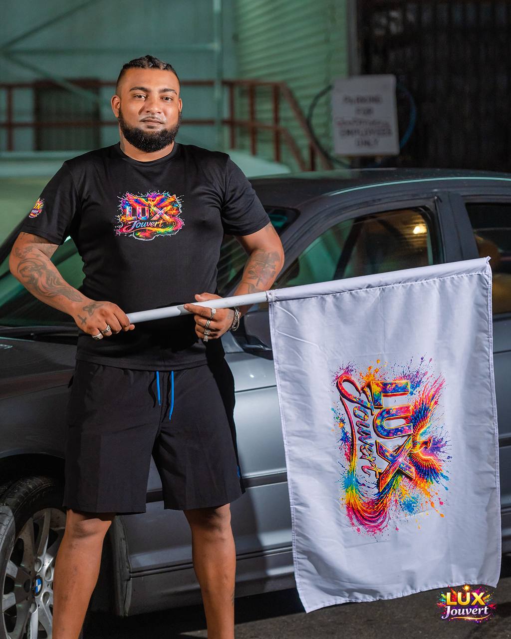 Band rep holding the LUX J'Ouvert phoenix flag