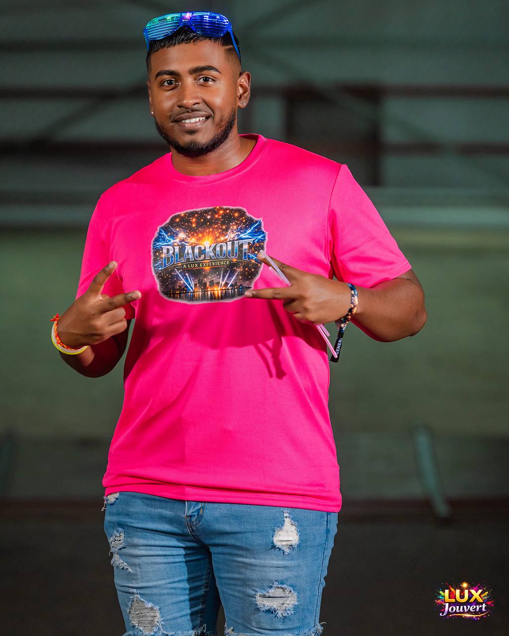 Reveller in a pink Blackout tee with LED glasses