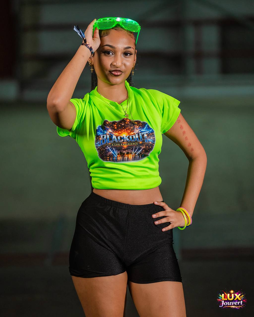 Reveller in a neon green Blackout crop top with LED glasses