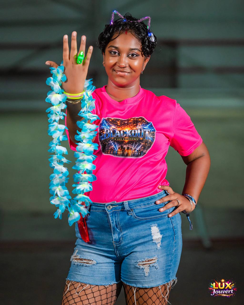 Reveller in a pink Blackout tee with light-up lei